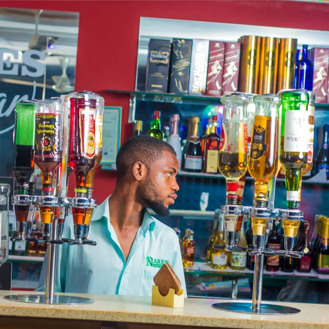 Bartender behind the well-stocked bar at the Satellite branch