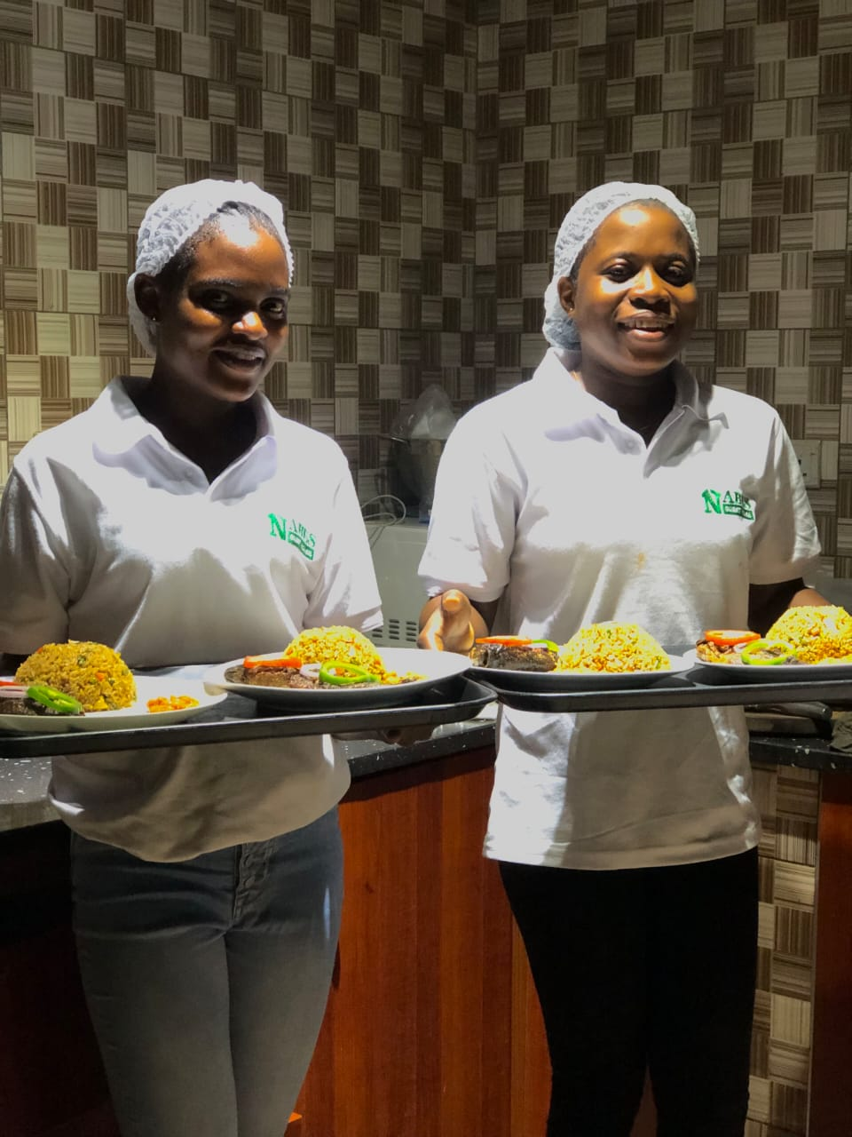 Kitchen team serving plated meals at the Satellite branch